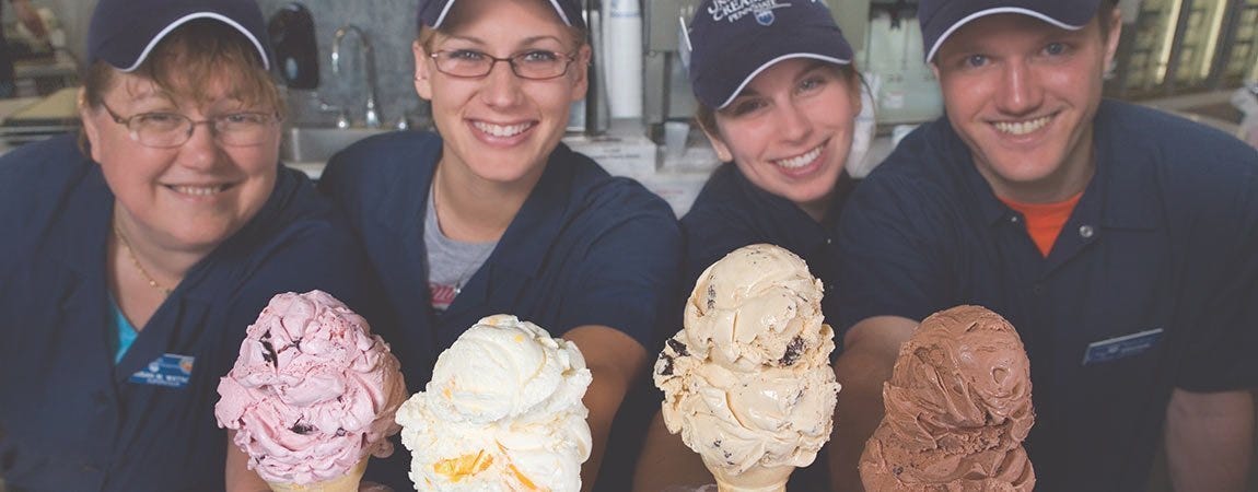 Creamery workers holding ice cream cones